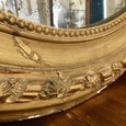 Miroir oval en bois et stuc doré style Louis XVI