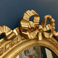 Miroir oval en bois et stuc doré style Louis XVI