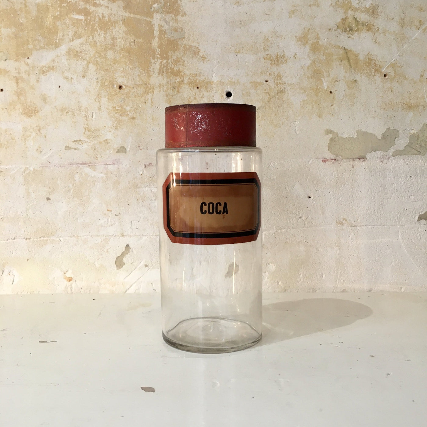 Grand pot de pharmacie en verre soufflé avec étiquette et couvercle en fer peint rouge